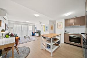 a kitchen and living room with a table at Stylish 1-Bed Unit with Secure Parking in Braddon