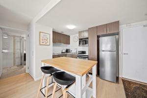 a kitchen with a wooden table and a refrigerator at Stylish 1-Bed Unit with Secure Parking in Braddon +12 photos