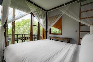 a bedroom with two beds and a window at Uma Stana Villa in Ubud