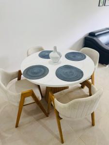een witte tafel met vier blauwe platen erop bij Apartamento Mallorca in Mirolindo