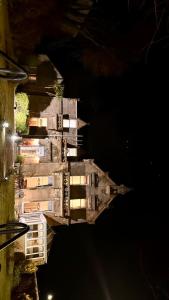 um edifício à noite com as luzes acesas em West Coates Mansion em Edinburgo