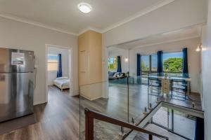 eine offene Küche und ein Wohnzimmer mit Glaswänden in der Unterkunft 64 Bathurst Street in Elliott Heads