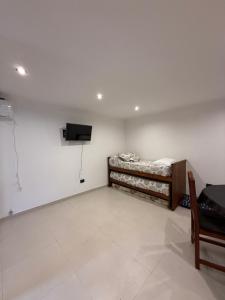 een kamer met een bed en een televisie aan de muur bij Dpto lo de Bruno in Santa Clara del Mar