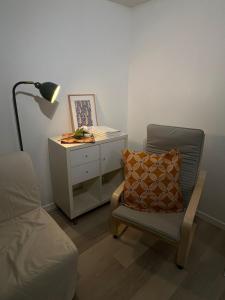 een slaapkamer met een stoel en een bureau met een lamp bij Le Montagnard, Studio cosy, centre de Montbrison in Montbrison