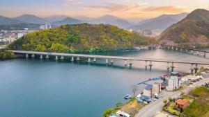 eine Brücke über einen Fluss neben einer Stadt in der Unterkunft Chuncheon El Dorado Kid's Pension in Gapyeong