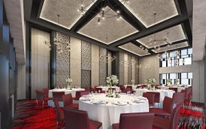 una sala da pranzo con tavoli bianchi e sedie rosse di Radisson RED Cebu Mandaue a Banilad