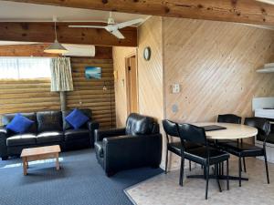 莱克斯恩特伦斯雷兹埃克的小木屋酒店的客厅里有一张沙发、一张桌子和几把椅子。