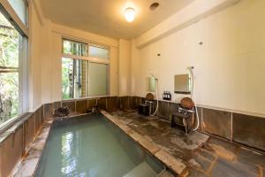 a large bathroom with a swimming pool in the floor at YUPOPPO Hakone in Hakone
