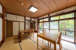 a dining room with a table and chairs and windows at YUPOPPO Hakone in Hakone