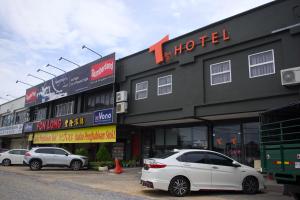 a white car parked in front of a hotel at T Hotel Tandop in Alor Setar