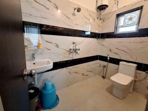 a bathroom with a toilet and a sink at Sublime Homestay in Bhubaneshwar +247 photos