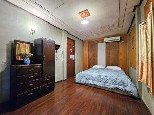 een slaapkamer met een bed, een ladekast en een spiegel bij The Florist Ayutthaya in Phra Nakhon Si Ayutthaya