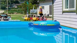 a swimming pool with two inflatable tubes in the water at Gapyeong Maplein Pension in Pocheon