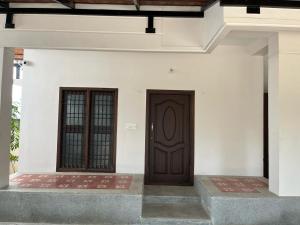 une paire de portes sur un bâtiment blanc dans l'établissement Raj Nivas, à Mayiladuthurai 2 autres photos