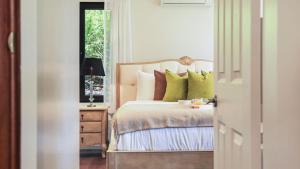 ein Schlafzimmer mit einem Bett und einem Tisch mit einer Lampe in der Unterkunft Goolara in Burrawang