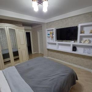 une chambre avec un lit et une télévision à écran plat dans l'établissement Apartament Buiucani Alba Iulia, à Chişinău