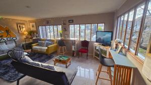 a living room with a couch and a table with a television at Hostel del Lago, habitaciones privadas y cabañas in El Chalten