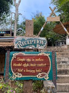 Un cartel de una casa de terapia con escaleras al fondo. en Styles Stay, en Mae Hong Son