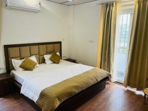 una camera da letto con un letto grande e una finestra di Simran Aura Resort a Dehradun