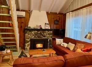 uma sala de estar com sofá e lareira em Chalets Village Suisse de Val-David em Val-David