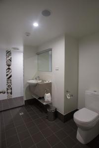 a bathroom with a toilet and a sink at Gladstone Reef Hotel Motel in Gladstone
