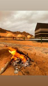 un incendio nel deserto con un edificio sullo sfondo di Desert calm a Wadi Rum