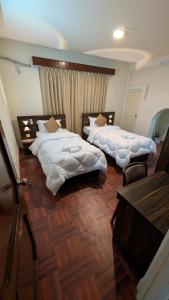 a bedroom with two beds and a table and a desk at Apartment in kathmandu in Kathmandu