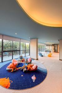 a lobby with two children laying on a blue rug at Kora 2br pool Apartment in Layan Beach