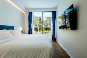 a bedroom with a large bed and a window at Kora 2br pool Apartment in Layan Beach +59 photos