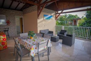 a patio with a table and chairs and a balcony at BELLA House in Gros-Morne