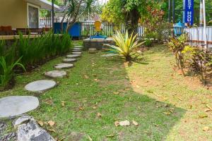 Un jardín con escalones sobre el césped. en RedDoorz Plus near Brawijaya Museum, en Malang