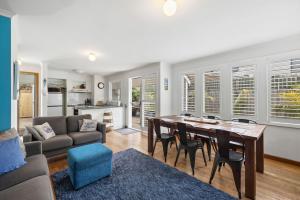 een keuken en woonkamer met een tafel en stoelen bij Price on the Beach 2c in Torquay