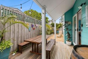 een houten terras met een houten tafel en bank bij een huis bij Price on the Beach 2c in Torquay
