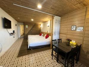 Un dormitorio con una cama y una mesa dentro. en 九份迦南民宿, en Jiufen