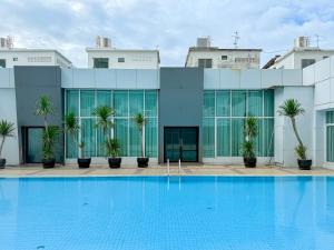 a building with a pool in front of it at Avana Residence in Bangna