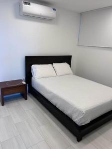 Cama en habitación con mesita de noche y cama sidx sidx sidx sidx sidx en departamento salinas, en Salinas