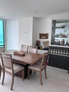 Un comedor con mesa y sillas de madera. en departamento salinas, en Salinas