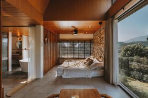 Un dormitorio con una cama y una ventana grande. en The CAMPIAN, en Chiang Mai