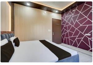 een slaapkamer met een groot bed met een paarse muur bij Sokoon Home Stay in Morādābād