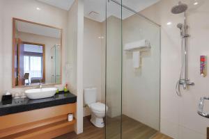 a bathroom with a sink and a toilet and a shower at favehotel Nagoya - Batam in Batam Center +9 photos