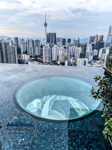 a swimming pool on top of a building with a city at Lucentia Residence by EAS Maju property in Kuala Lumpur