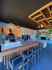 Una cocina con una barra larga con taburetes azules. en Hotel Pousada Laguna Rosa, en Barra de Ibiraquera