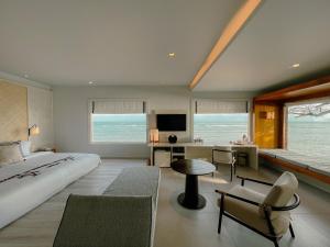 a bedroom with a large bed and a living room at Rocky's Boutique Resort - Veranda Collection Samui in Lamai