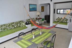 sala de estar con hamaca, mesa y sillas en Casa Los Almendros, en Melgar