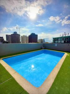 een groot blauw zwembad op het dak van een gebouw bij Cozy Studio near Sydney Hyde Park with Rooftop Pool & FREE Parking in Sydney