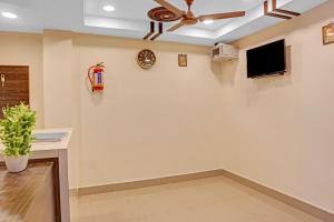 a living room with a ceiling fan and a wall at Hotel O Ramya Inn in Warangal