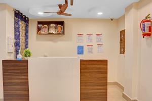 a lobby with a white counter and a ceiling fan at Hotel O Ramya Inn in Warangal +21 photos