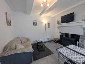 a living room with a couch and a fireplace at Au petit café in Châteauvillain
