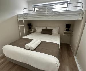 1 Schlafzimmer mit einem Bett mit 2 Etagenbetten in der Unterkunft BIG4 Apollo Bay Pisces Holiday Park in Apollo Bay