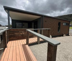 a building with a wooden deck with a railing at BIG4 Apollo Bay Pisces Holiday Park in Apollo Bay